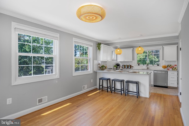 1305 Heather Hill Rd, Baltimore, MD 21239 - kitchen featuring dishwasher, healthy amount of natural light, white cabinetry, tasteful backsplash, and ornamental molding