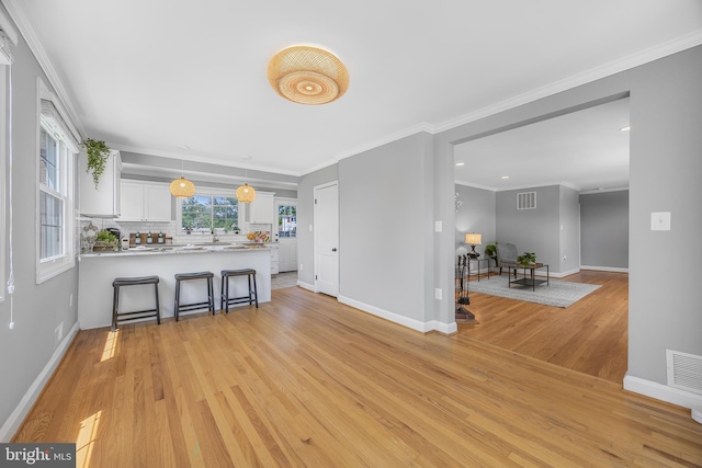 1305 Heather Hill Rd, Baltimore, MD 21239 - kitchen with light wood finished floors, white cabinetry, a peninsula, light countertops, and backsplash