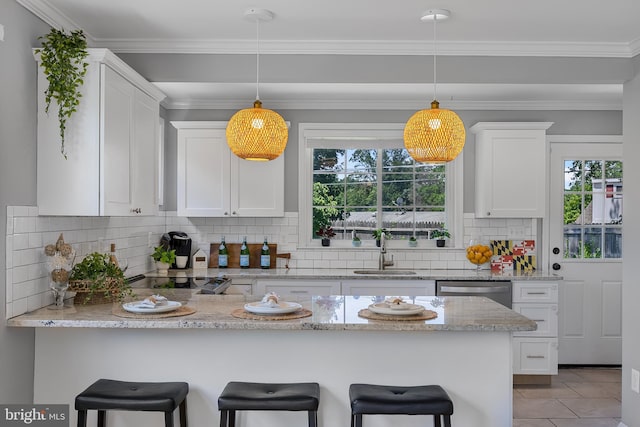 1305 Heather Hill Rd, Baltimore, MD 21239 - kitchen with a peninsula, white cabinetry, a kitchen bar, backsplash, and pendant lighting