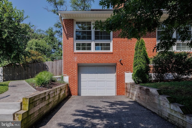 1305 Heather Hill Rd, Baltimore, MD 21239 - view of front of home with asphalt driveway, brick siding, and an attached garage