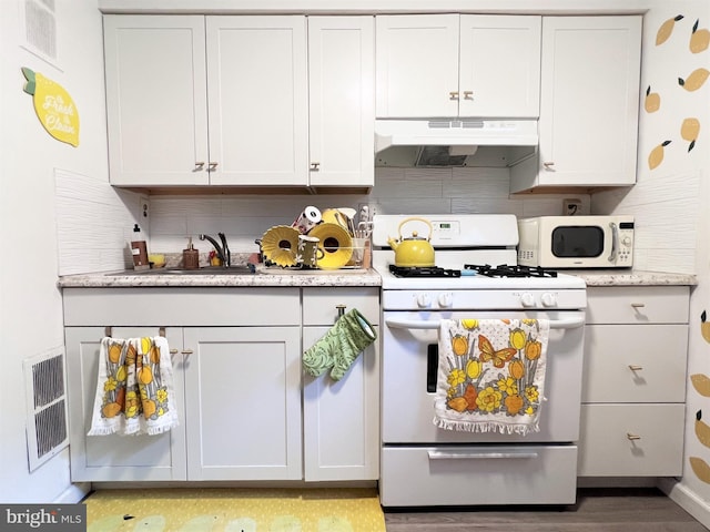 316-322 W Wildey St, Philadelphia, PA 19123 - kitchen featuring white appliances, under cabinet range hood, tasteful backsplash, light wood-type flooring, and white cabinetry
