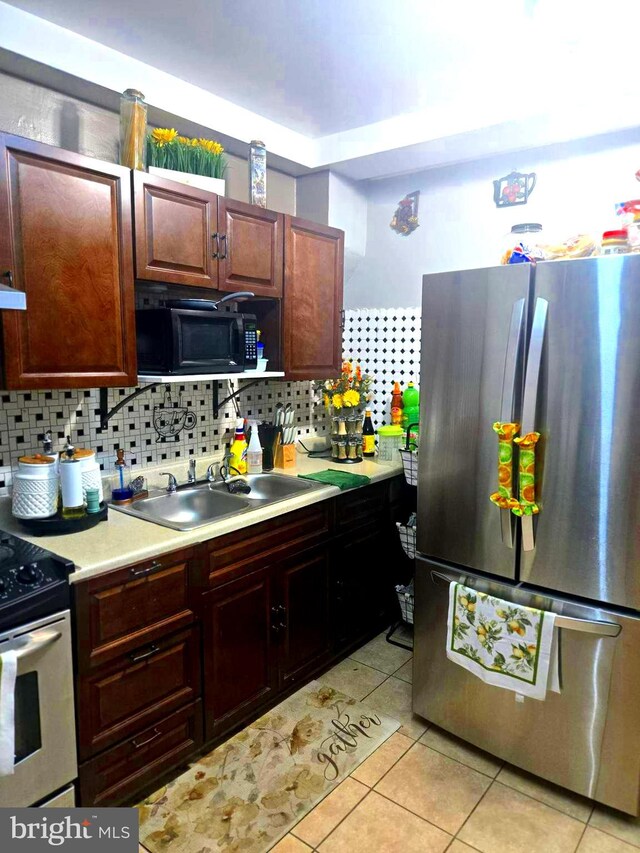 458 W Oley St, Reading, PA 19601 - kitchen featuring appliances with stainless steel finishes, light countertops, decorative backsplash, and light tile patterned flooring