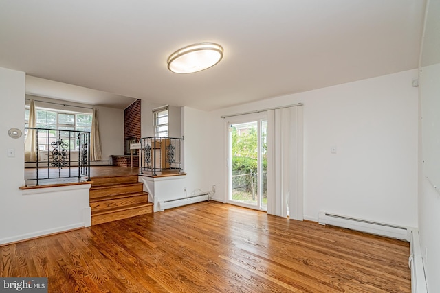 1916 Porter Ave, Suitland, MD 20746 - unfurnished living room with a baseboard heating unit, wood finished floors, stairway, and a baseboard radiator