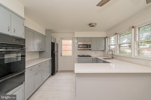1916 Porter Ave, Suitland, MD 20746 - kitchen with black appliances, a warming drawer, gray cabinetry, decorative backsplash, and light countertops