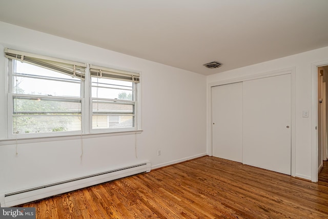 1916 Porter Ave, Suitland, MD 20746 - unfurnished bedroom with a baseboard heating unit, wood finished floors, and a closet