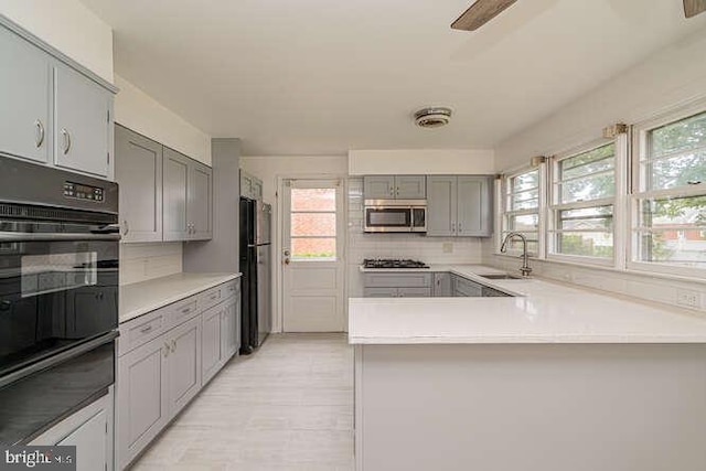1916 Porter Ave, Suitland, MD 20746 - kitchen featuring black appliances, a warming drawer, gray cabinets, backsplash, and light countertops