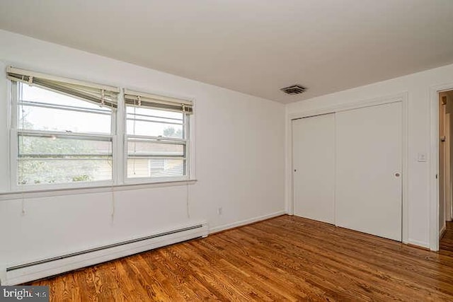1916 Porter Ave, Suitland, MD 20746 - unfurnished bedroom featuring a baseboard radiator, wood finished floors, multiple windows, and a closet