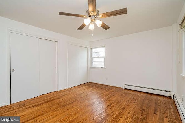 1916 Porter Ave, Suitland, MD 20746 - unfurnished bedroom with a baseboard radiator, wood finished floors, multiple closets, and ceiling fan