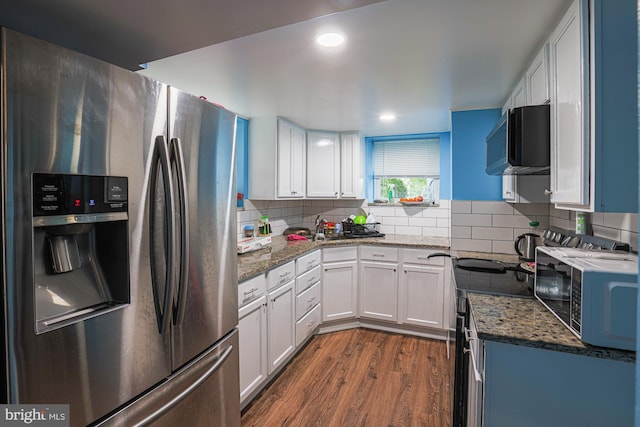 8935 Twin Ridge Dr, Glen Burnie, MD 21061 - kitchen featuring appliances with stainless steel finishes, dark wood-style floors, white cabinets, dark stone counters, and decorative backsplash