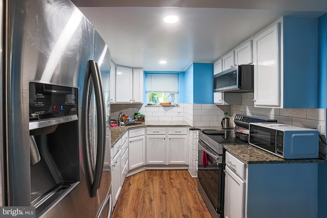 8935 Twin Ridge Dr, Glen Burnie, MD 21061 - kitchen with stainless steel appliances, wood finished floors, white cabinets, dark stone counters, and tasteful backsplash