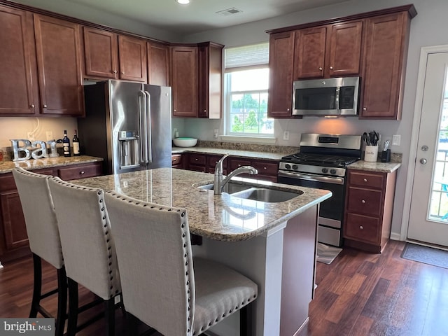 108 Creekside Way, Burlington, NJ 08016 - kitchen featuring appliances with stainless steel finishes, dark wood finished floors, light stone counters, a kitchen bar, and an island with sink