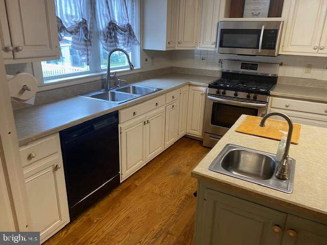 21 Willow St, Milroy, PA 17063 - kitchen with appliances with stainless steel finishes, dark wood-style flooring, light countertops, white cabinets, and open shelves