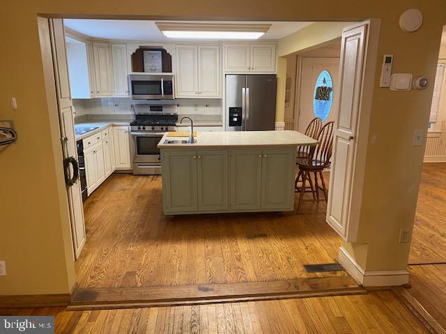 21 Willow St, Milroy, PA 17063 - kitchen featuring appliances with stainless steel finishes, light countertops, wood finished floors, and a kitchen island with sink