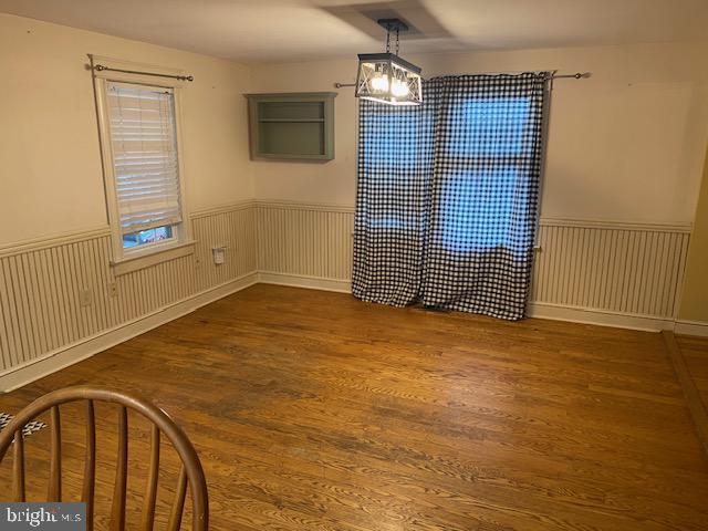 21 Willow St, Milroy, PA 17063 - unfurnished dining area with wood finished floors, wainscoting, and a chandelier