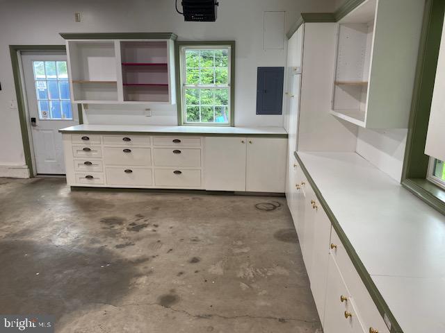 21 Willow St, Milroy, PA 17063 - kitchen featuring open shelves, electric panel, concrete floors, light countertops, and white cabinetry