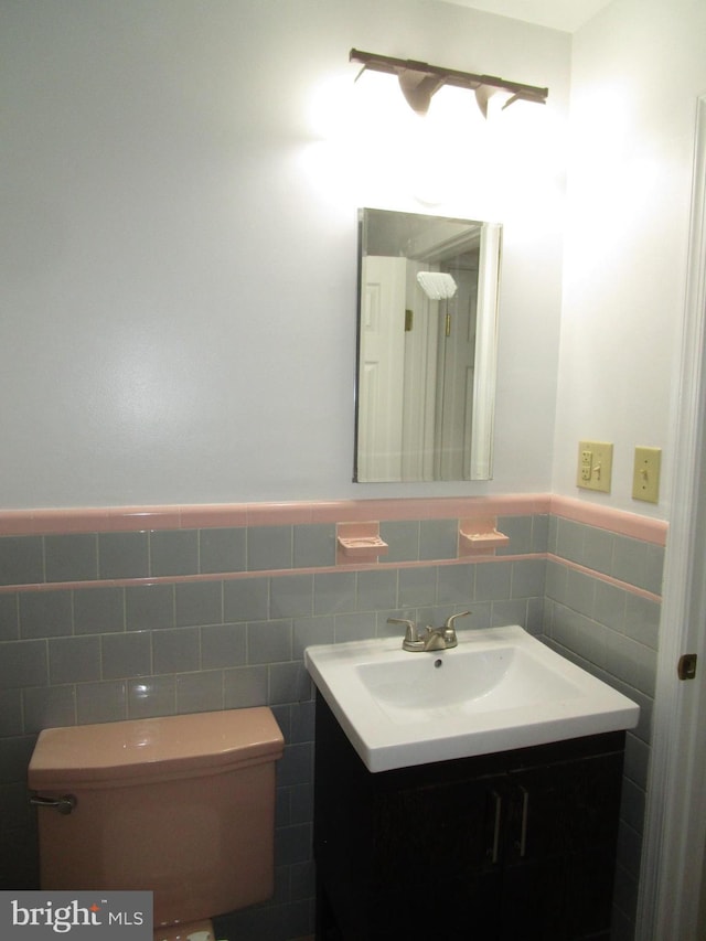 5606 Devon Ct, Temple Hills, MD 20748 - half bathroom featuring vanity, tile walls, and a wainscoted wall