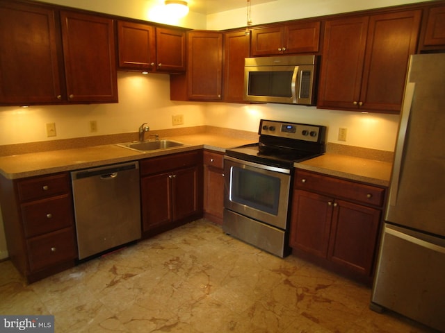 5606 Devon Ct, Temple Hills, MD 20748 - kitchen with stainless steel appliances, light marble finish floors, and reddish brown cabinets