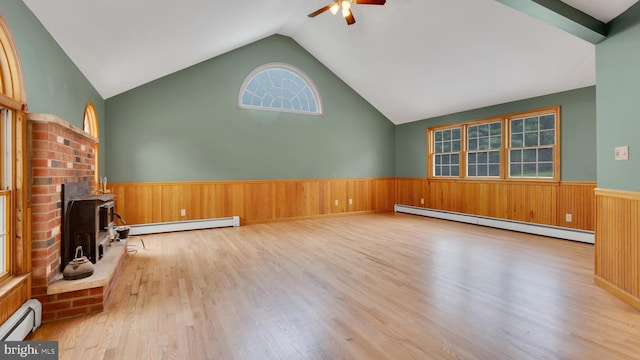 132 Sycamore Dr, Palmerton, PA 18071 - unfurnished living room featuring baseboard heating, a wood stove, ceiling fan, a wainscoted wall, and wooden walls