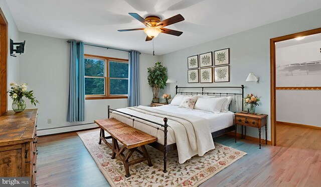 132 Sycamore Dr, Palmerton, PA 18071 - bedroom featuring baseboard heating, wood finished floors, a walk in closet, and a ceiling fan