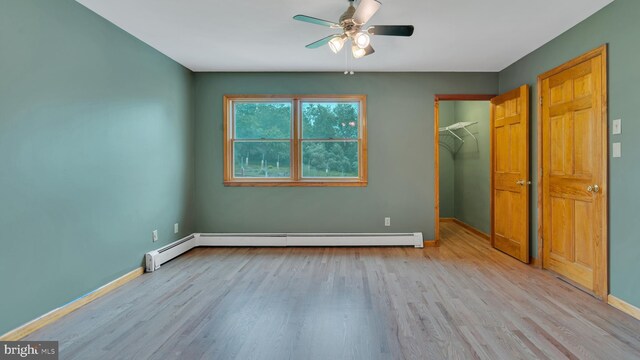 132 Sycamore Dr, Palmerton, PA 18071 - unfurnished bedroom featuring wood finished floors, a baseboard radiator, a spacious closet, and ceiling fan