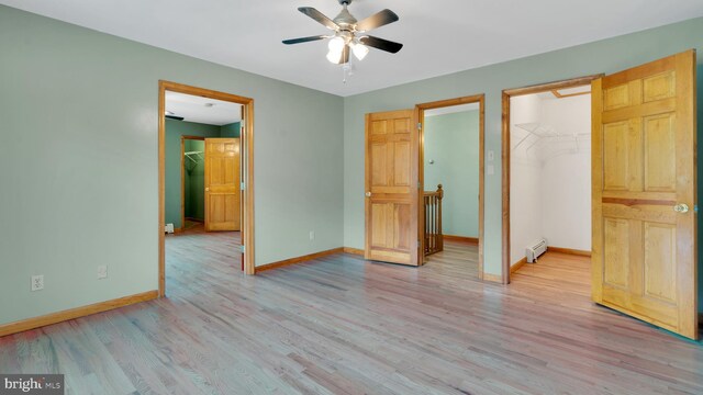 132 Sycamore Dr, Palmerton, PA 18071 - unfurnished bedroom featuring a spacious closet, light wood-type flooring, a closet, a ceiling fan, and a baseboard radiator