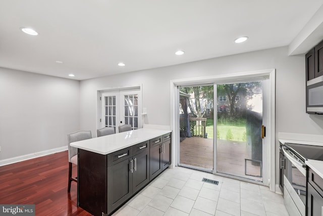 9046 Queen Maria Ct, Columbia, MD 21045 - kitchen featuring stainless steel appliances, french doors, a kitchen bar, a peninsula, and recessed lighting