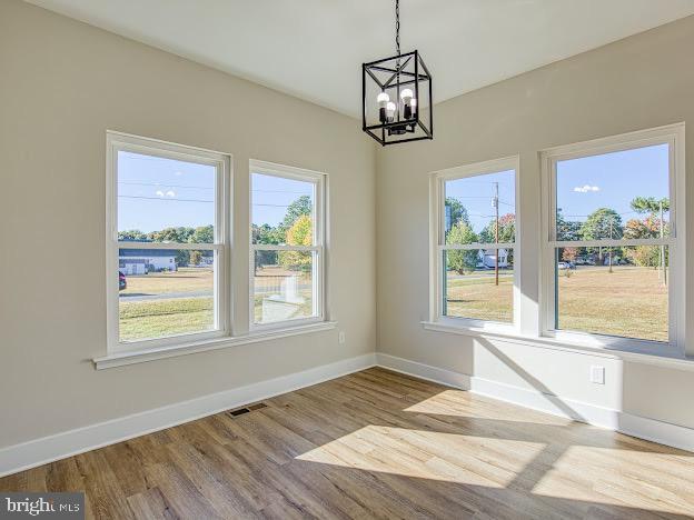 103 Woodland Dr, Montross, VA 22520 - unfurnished dining area with a chandelier, healthy amount of natural light, and wood finished floors