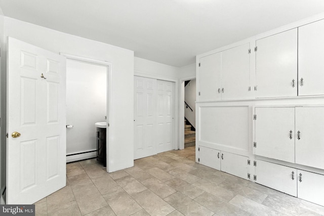 312 Wellington, Reading, PA 19609 - unfurnished bedroom featuring baseboard heating, multiple closets, and stone finish flooring