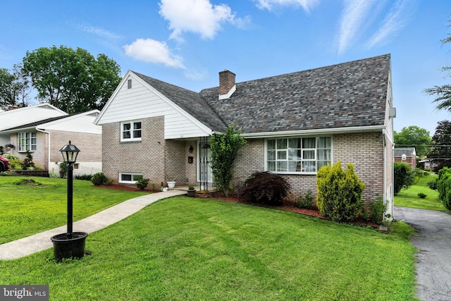 312 Wellington, Reading, PA 19609 - split level home featuring brick siding, a front yard, and a chimney