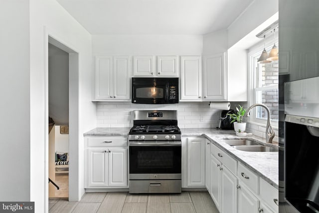 312 Wellington, Reading, PA 19609 - kitchen with gas range, black microwave, white cabinetry, fridge, and decorative backsplash