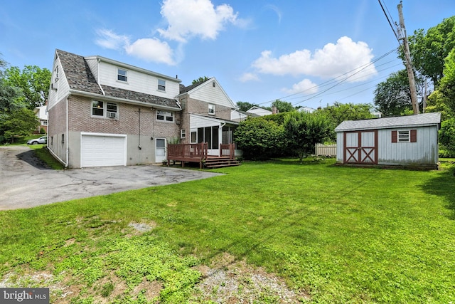 312 Wellington, Reading, PA 19609 - rear view of property with a garage, a deck, asphalt driveway, a lawn, and a storage unit