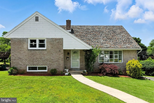 312 Wellington, Reading, PA 19609 - view of front of house featuring brick siding, a front yard, and a chimney