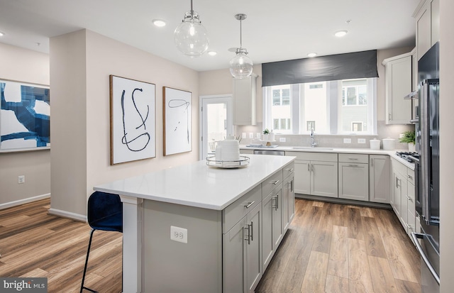 3929 Walnut St, Fairfax, VA 22030 - kitchen featuring light wood-style flooring, light countertops, a kitchen island, a breakfast bar area, and recessed lighting