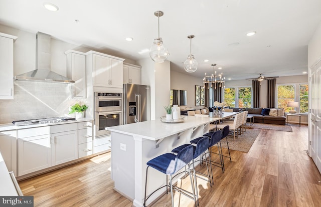 3929 Walnut St, Fairfax, VA 22030 - kitchen with wall chimney exhaust hood, appliances with stainless steel finishes, recessed lighting, a center island, and light countertops