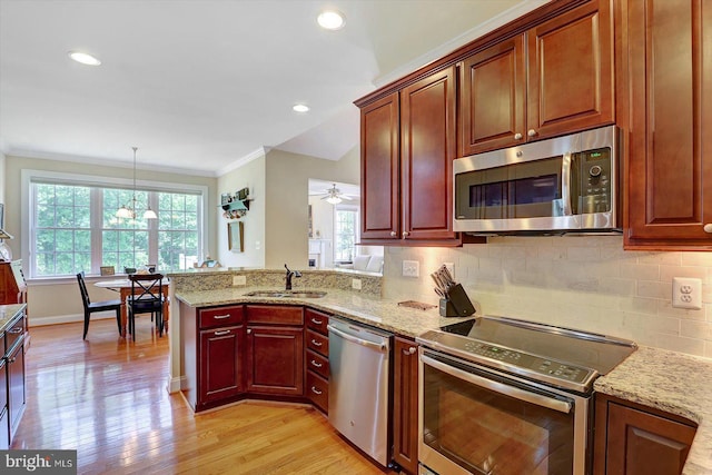 134 Woodhaven Dr, Gettysburg, PA 17325 - kitchen featuring appliances with stainless steel finishes, ornamental molding, light wood-type flooring, backsplash, and light stone countertops