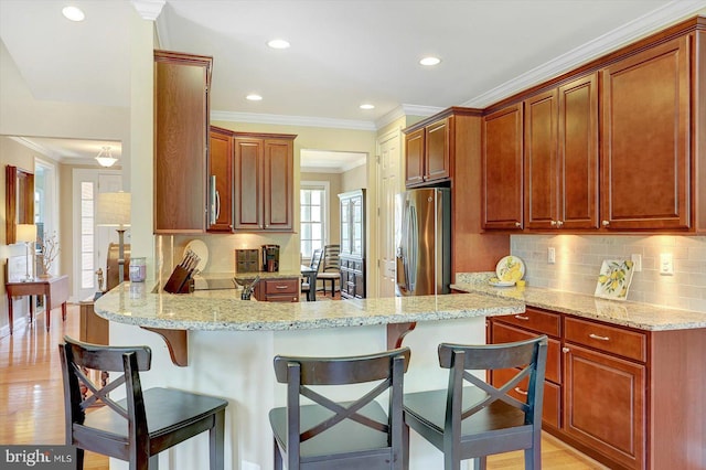 134 Woodhaven Dr, Gettysburg, PA 17325 - kitchen featuring stainless steel fridge with ice dispenser, a peninsula, a kitchen breakfast bar, backsplash, and crown molding