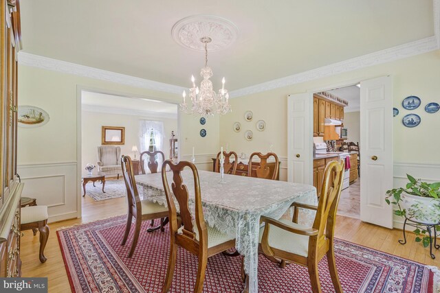 1202 Forestville Dr, Great Falls, VA 22066 - dining room with a chandelier, wainscoting, light wood finished floors, and ornamental molding