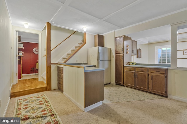 1202 Forestville Dr, Great Falls, VA 22066 - kitchen with freestanding refrigerator, a peninsula, brown cabinets, light countertops, and light carpet