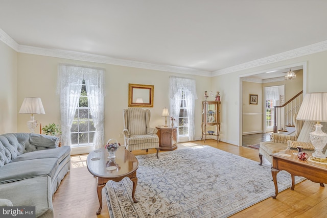 1202 Forestville Dr, Great Falls, VA 22066 - living area with healthy amount of natural light, ornamental molding, light wood finished floors, and stairs