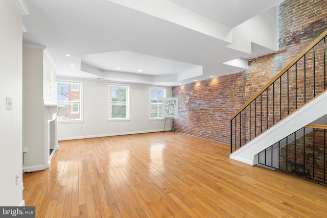 1401 Druid Hill Ave, Baltimore, MD 21217 - unfurnished living room featuring brick wall, stairway, hardwood / wood-style floors, a tray ceiling, and recessed lighting