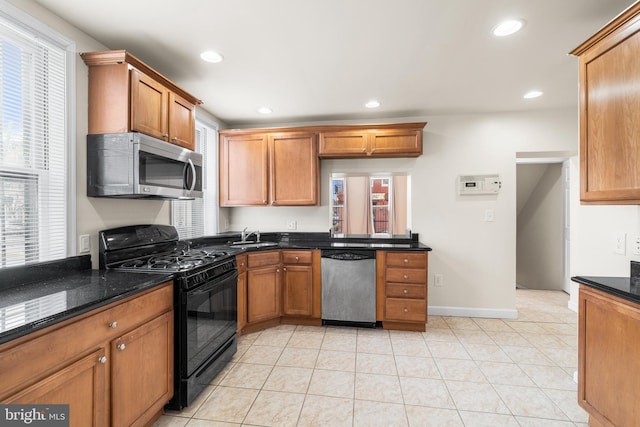 1401 Druid Hill Ave, Baltimore, MD 21217 - kitchen with stainless steel appliances, recessed lighting, brown cabinetry, light tile patterned flooring, and dark stone countertops