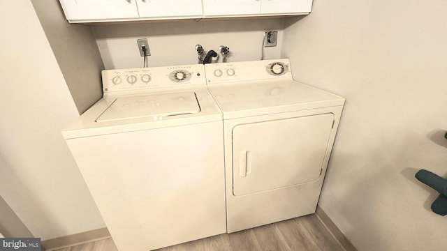 3695 S Leisure World Blvd Unit 14-A, Silver Spring, MD 20906 - laundry area featuring separate washer and dryer, cabinet space, and light wood-style flooring