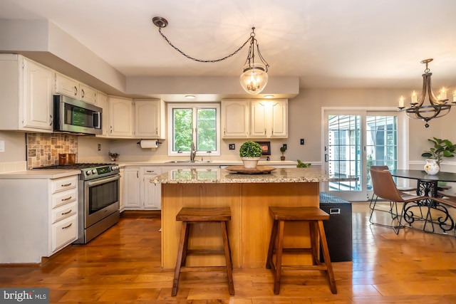 20 Mooney Ln, Chester Springs, PA 19425 - kitchen with appliances with stainless steel finishes, a chandelier, a kitchen island, white cabinets, and a kitchen bar