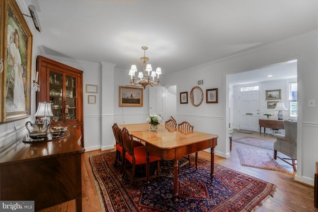 717 S Royal St, Alexandria, VA 22314 - dining space with wood finished floors, a chandelier, and crown molding