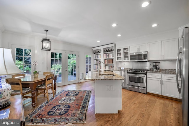 717 S Royal St, Alexandria, VA 22314 - kitchen with appliances with stainless steel finishes, french doors, light stone counters, white cabinets, and ornamental molding