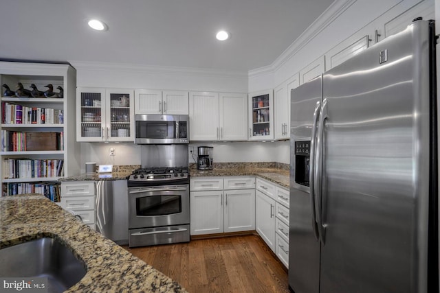 717 S Royal St, Alexandria, VA 22314 - kitchen with appliances with stainless steel finishes, ornamental molding, white cabinetry, glass insert cabinets, and dark wood-type flooring