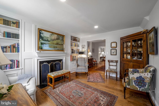 717 S Royal St, Alexandria, VA 22314 - living area featuring built in features, a fireplace with flush hearth, wood finished floors, crown molding, and recessed lighting