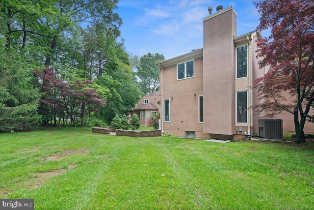 124 Kingsland Cir, Monmouth Junction, NJ 08852 - rear view of house featuring a chimney, a yard, and stucco siding