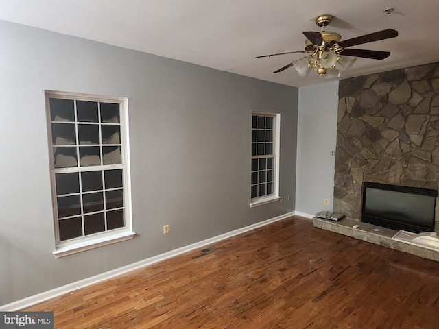 10203 Thundercloud Ct, Springdale, MD 20774 - unfurnished living room with a stone fireplace, wood finished floors, and ceiling fan