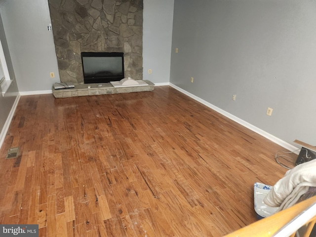 10203 Thundercloud Ct, Springdale, MD 20774 - unfurnished living room with wood finished floors and a stone fireplace